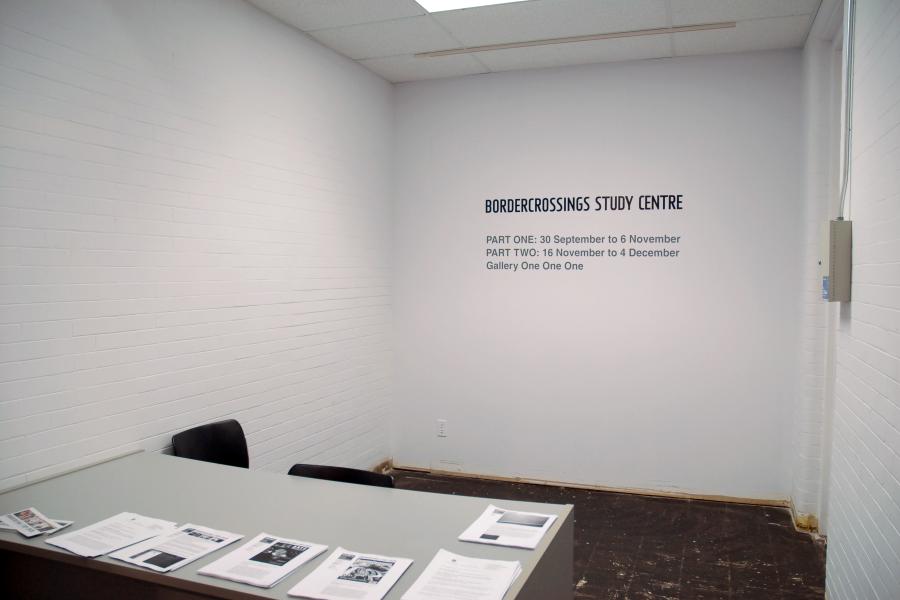 Gallery entrance to the BorderCrossings Study Centre exhibition with introductory wall text and a table displaying exhibition handouts and publications.