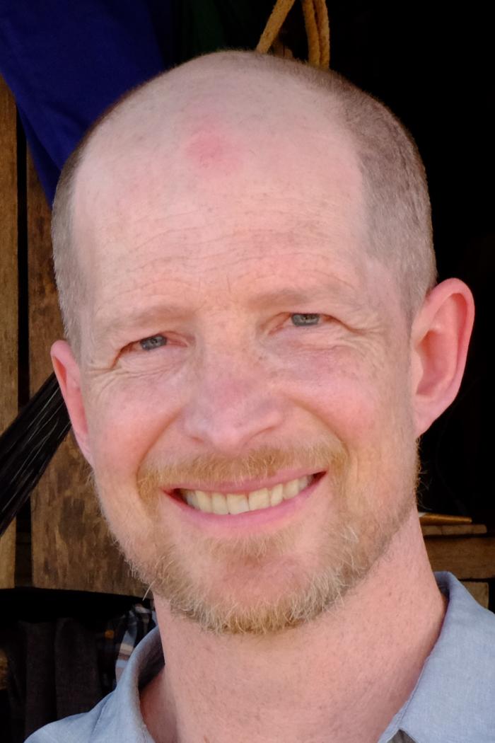 Headshot of man smiling.