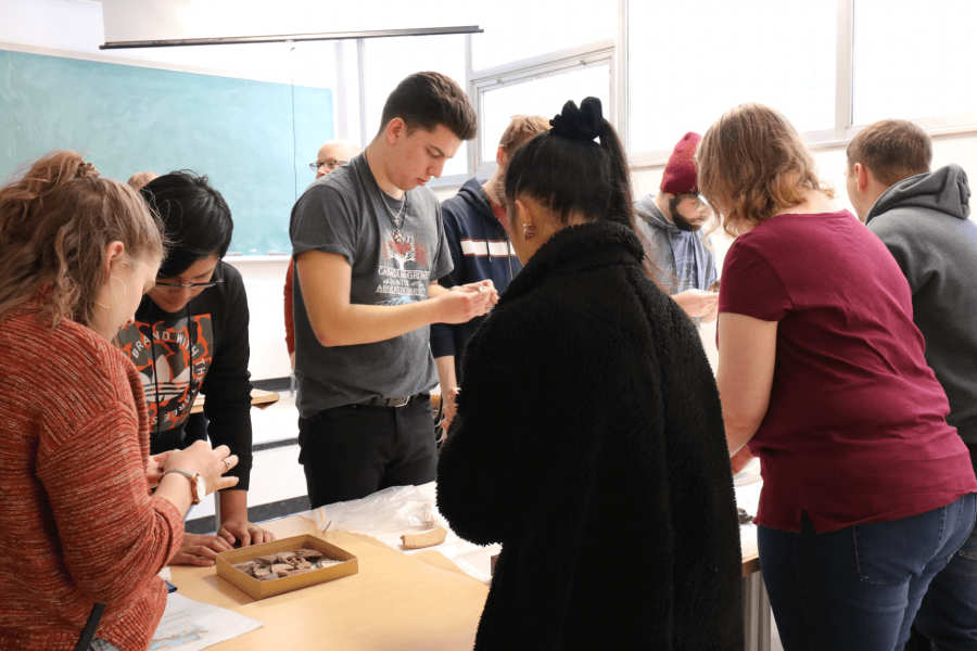 Students looking at artifacts in a classroom.