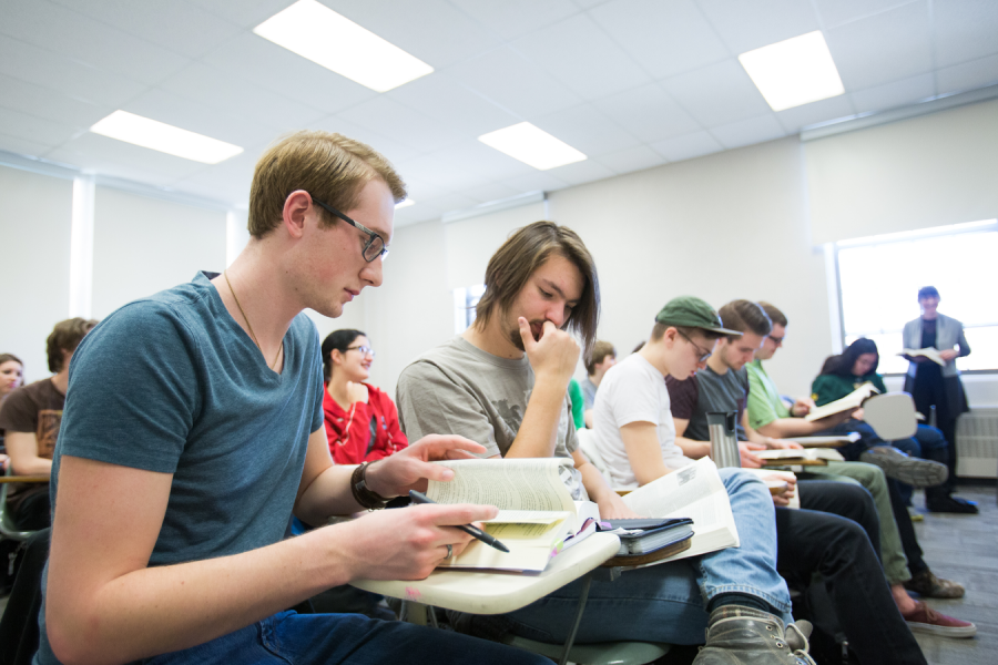 Two students read text during a lecture.