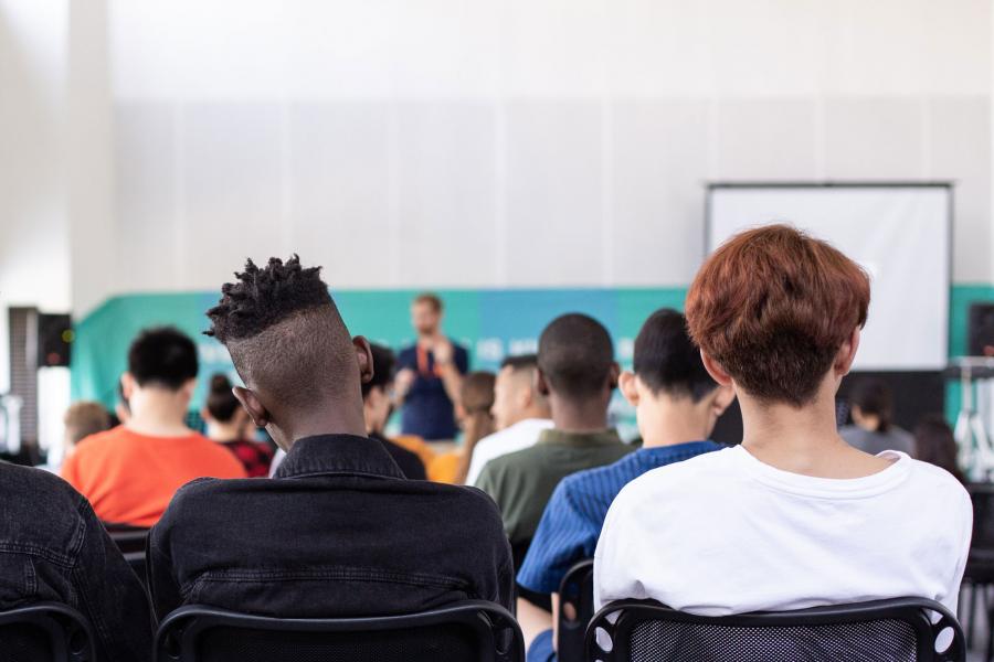 Back view of high school students seated listening to a presentation.