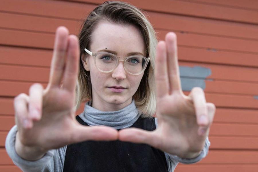 A film studies student holding their fingers up in a rectangle towards viewer.