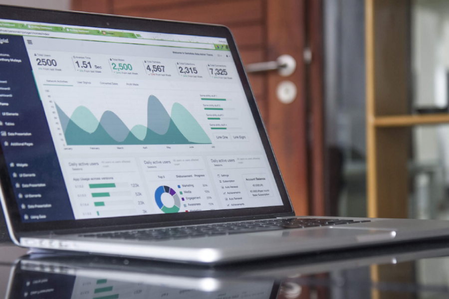 Open laptop showing a dashboard of graphs and data on the screen.