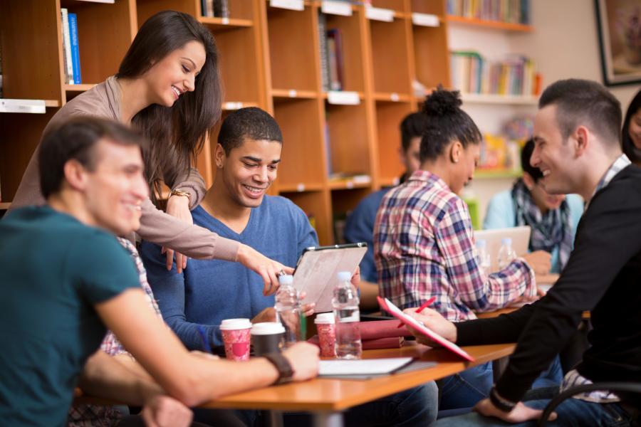 Group of students in a student lounge studying and drinking coffee.