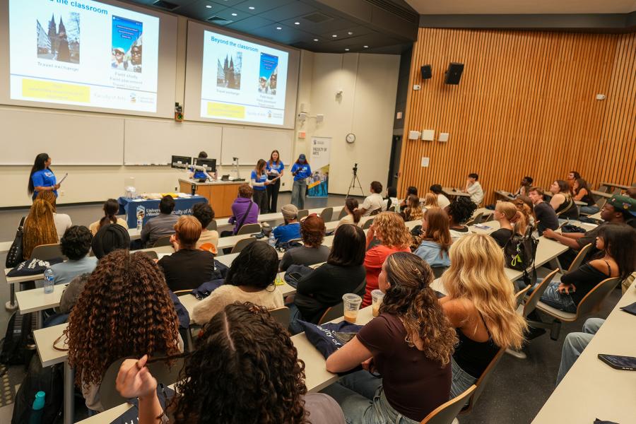 Students presenting to a lecture hall full of other students.