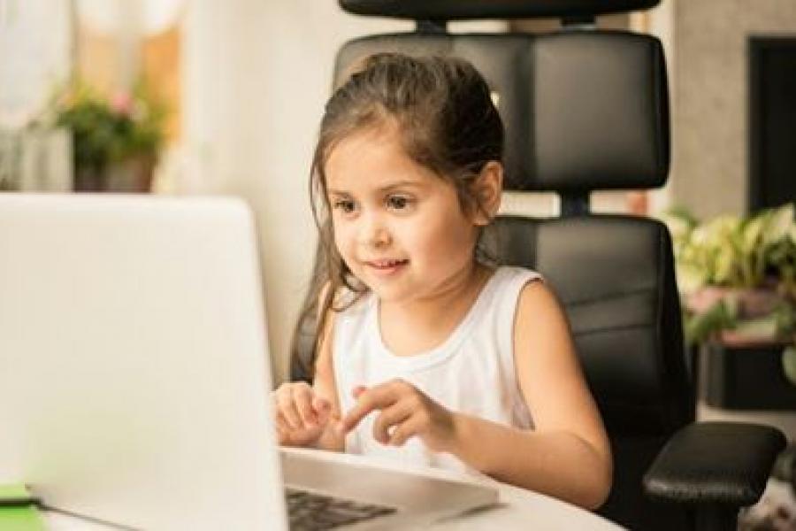 Young girl typing on a laptop. 