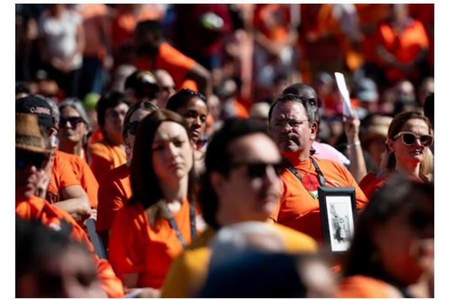 A crowd of people at a demonstration. All are wearing orange shirts.