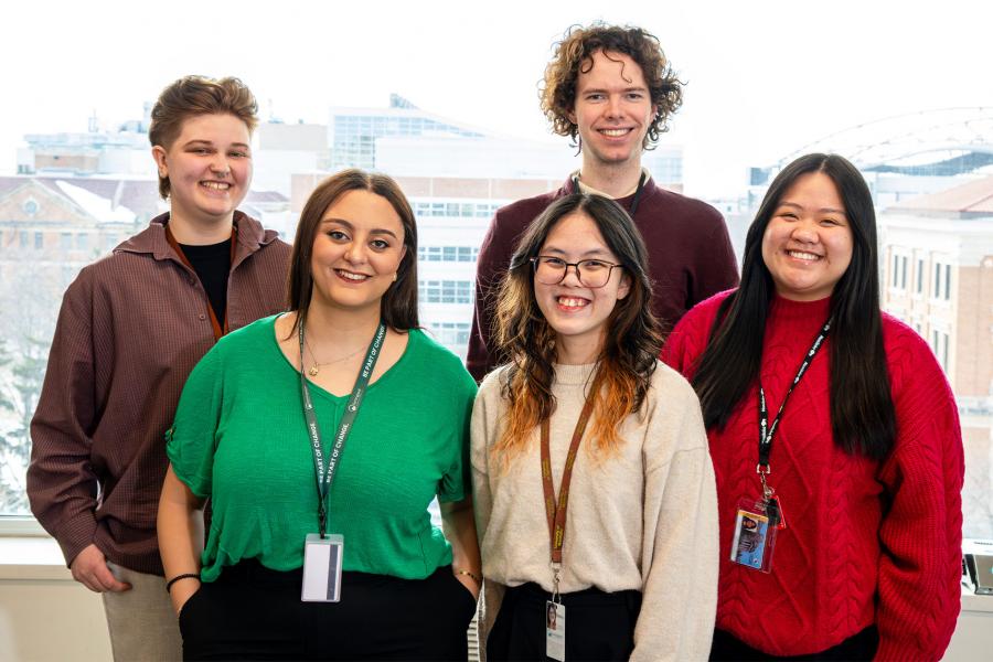 A mixed group of students standing in front of a window