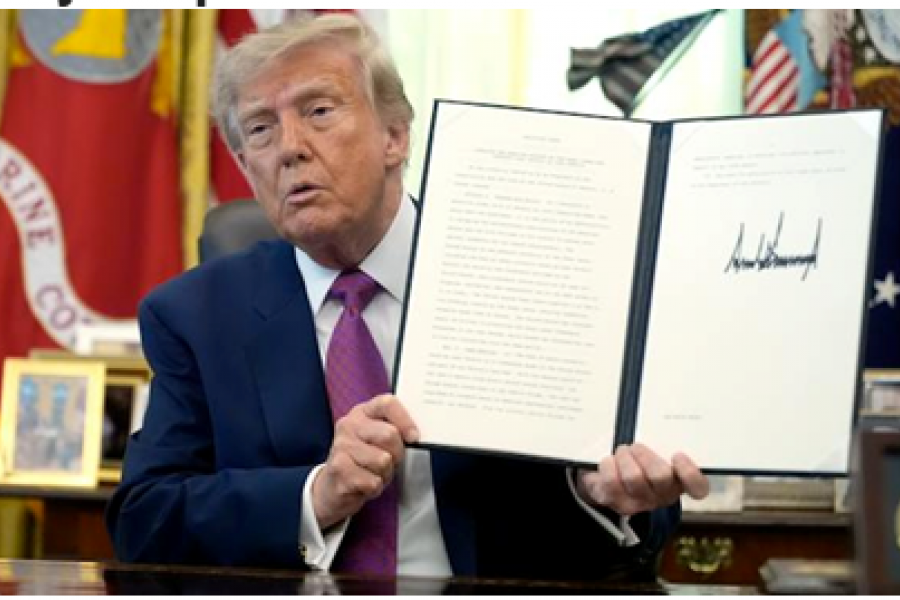 Donald Trump holding an open portfolio of an executive order he has just signed.
