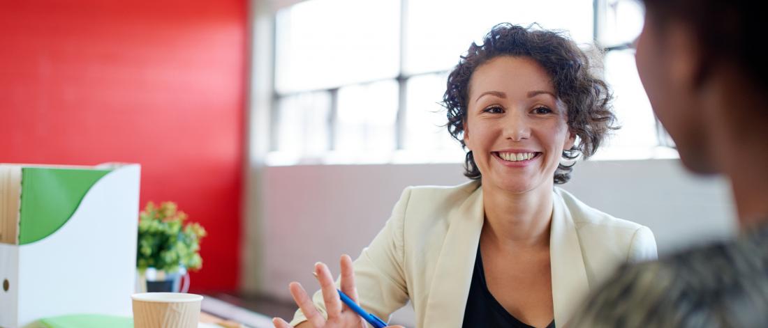 Business coach smiling with colleague.