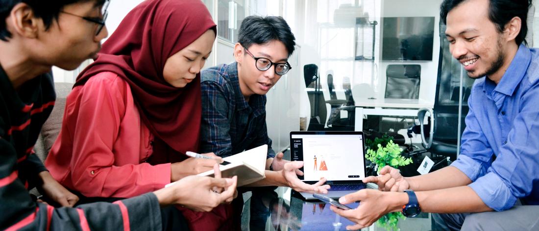 Four international students collaborate on a project