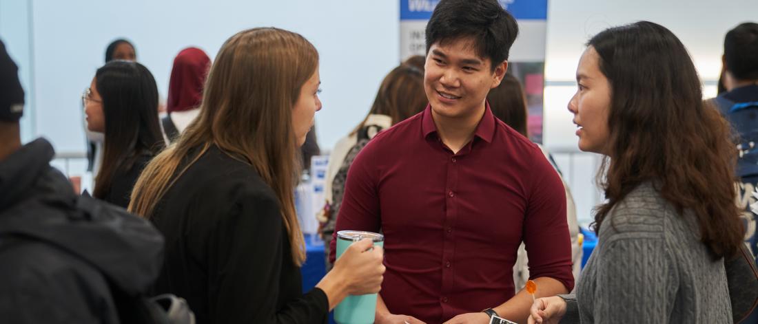 Photo of three students connecting at a career fair