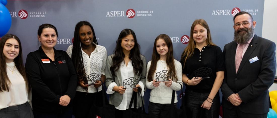 Image of high school students with industry leader and Asper dean. 