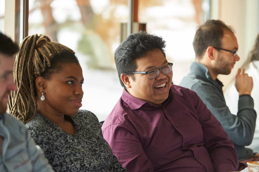 A row of students seated at an event laughing.