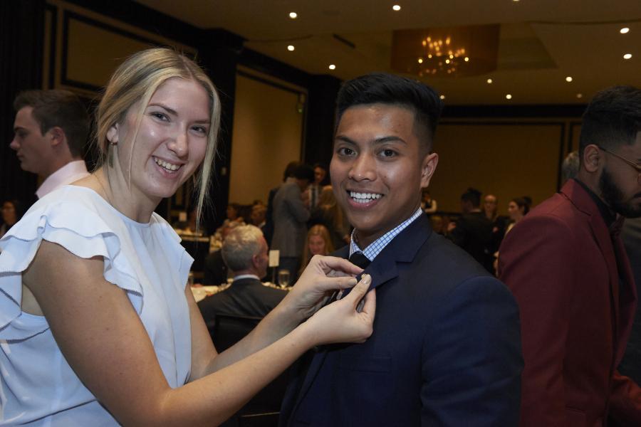 Female student putting an asper pin on a mail student