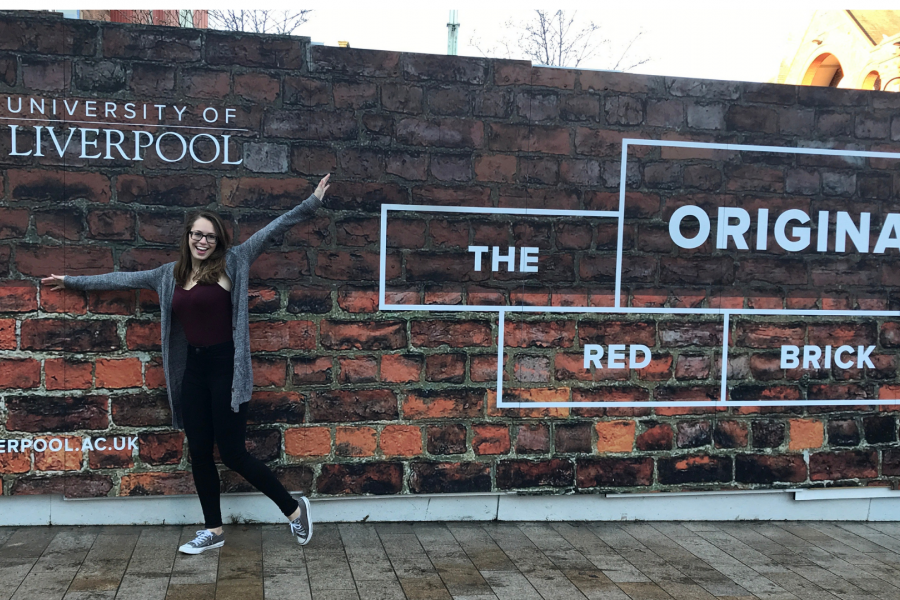 photo of a female student posing in front of the University of Liverpool sign