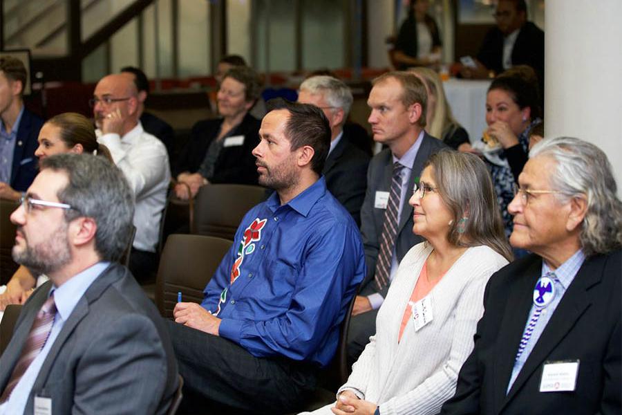 Group of adults sitting on chairs listening to a lecture.