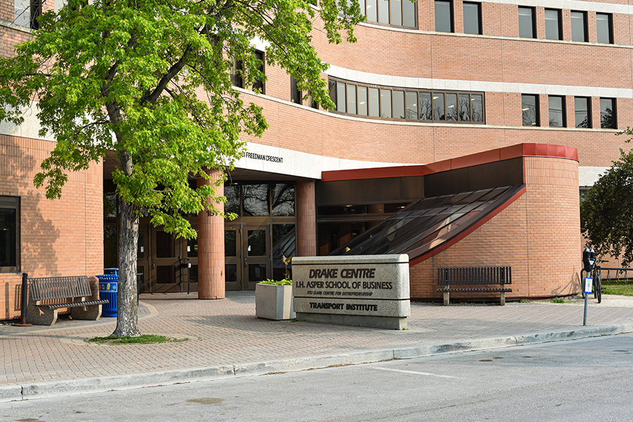 Exterior of the Drake Centre in summer, a green tree sits out front against the red brick.