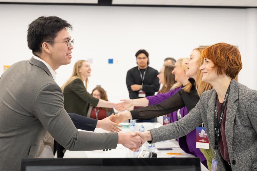A group of students shakes the hands of the group they are presenting to.