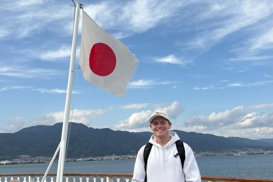 Young man standing in front of Japanese flag