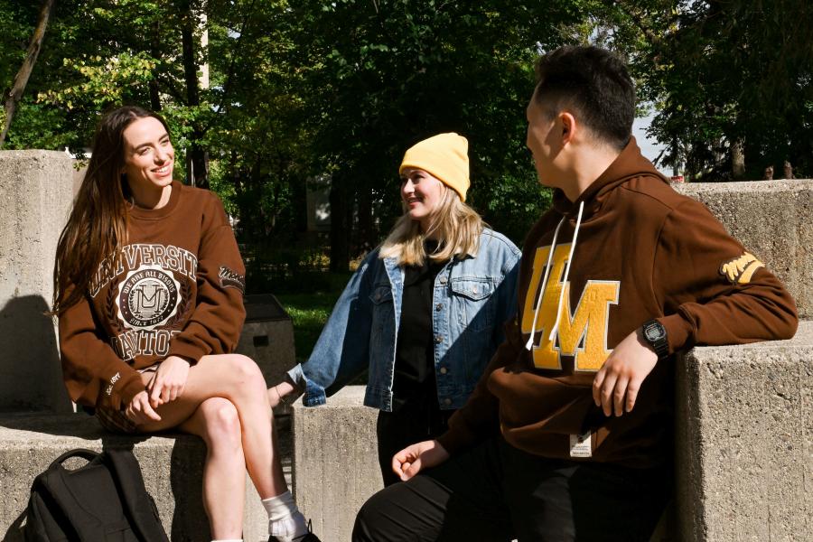 Three students smiling at each other