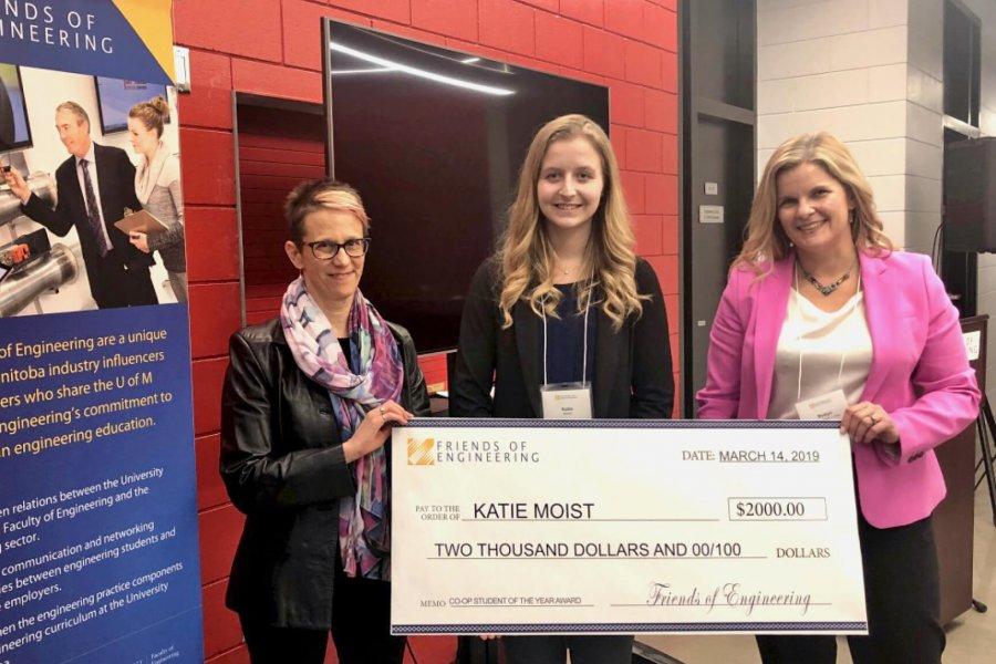 A large ceremonial cheque is presented to Katie Moist, the 2018-19 Engineering co-op student of the year. 