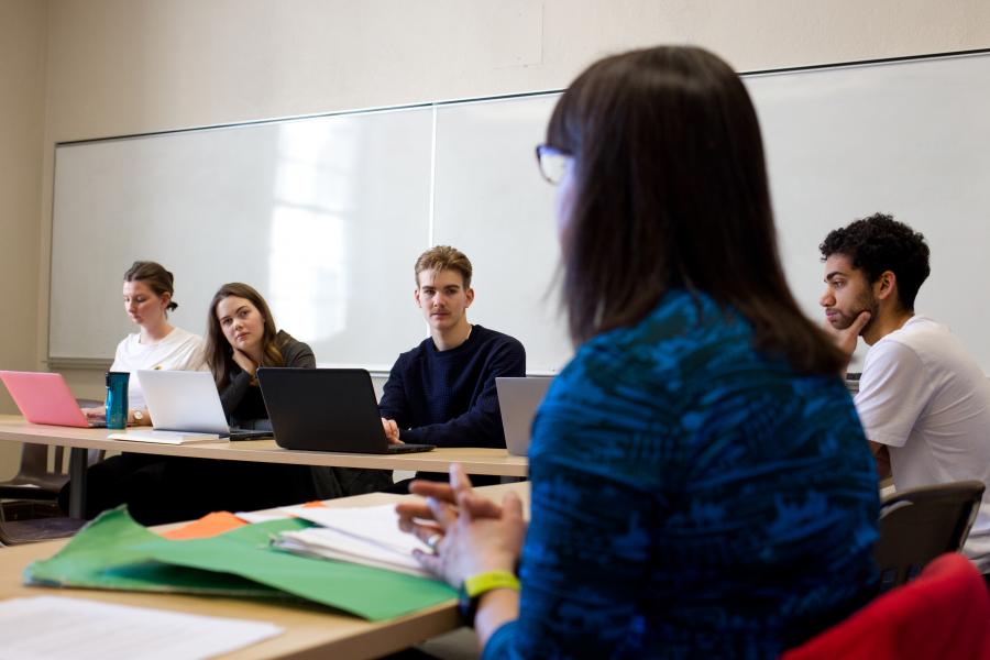 Instructor with students with laptops in class.