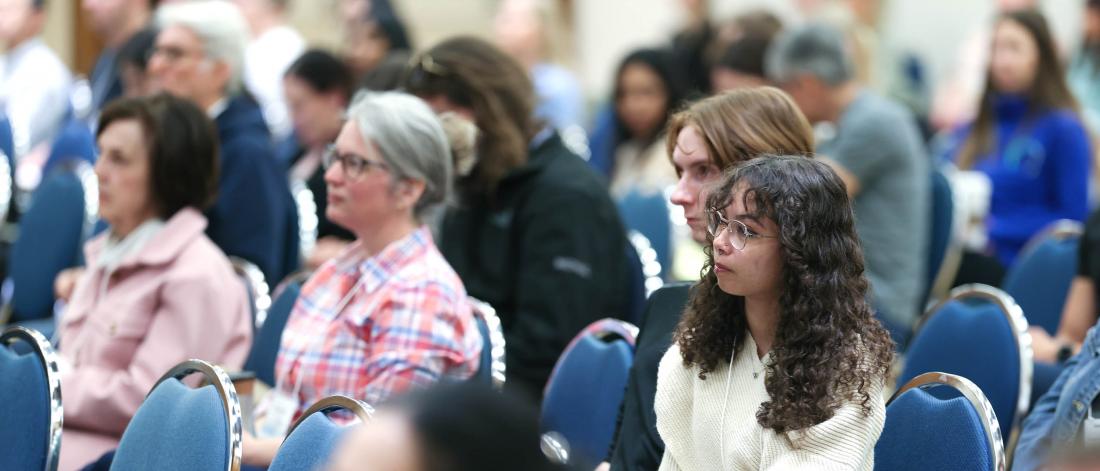 Audience members listen to a Symposium presentation