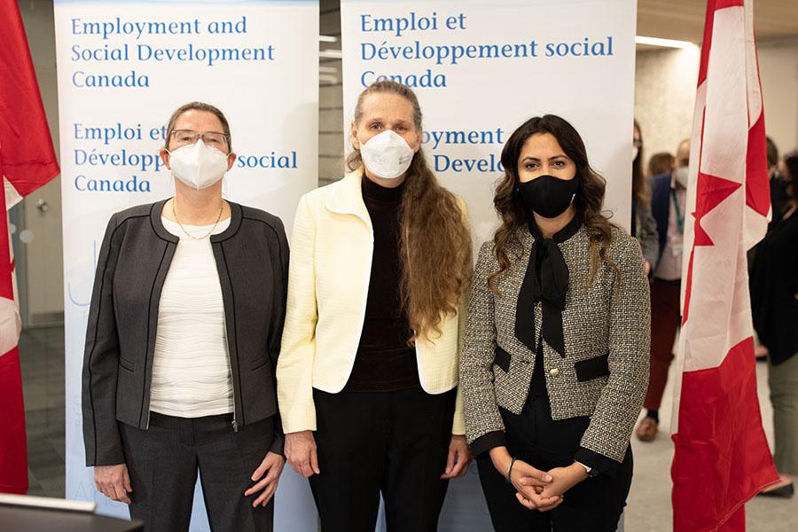 Drs. Farenhorst and Porter stand beside Minister Khera in front of two banners at the New Horizons funding announcement on May 16.