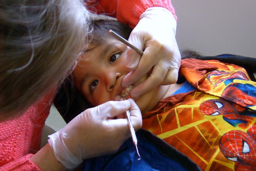 A child dental patient having teeth scaled in a dental clinic.