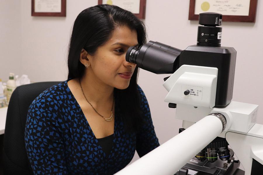 Dr. Vimi Mutalik looks into a microscope. 