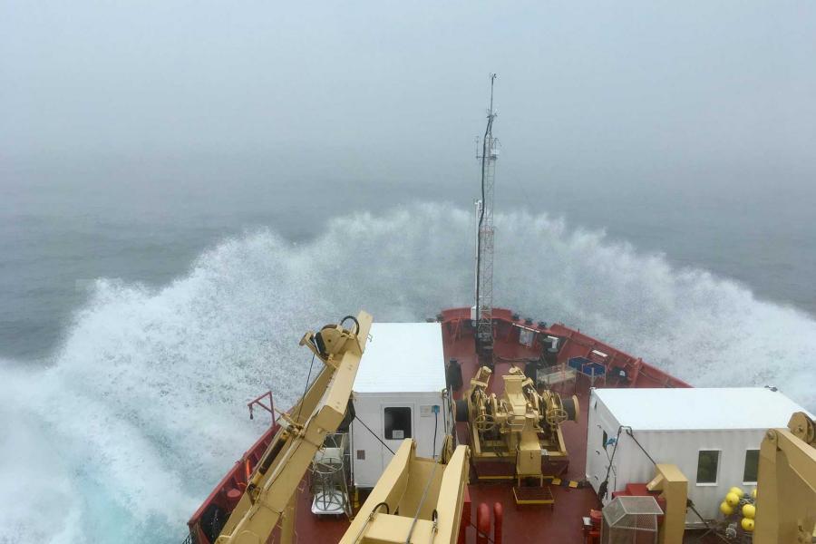 the bow of a boat breaking through waves.