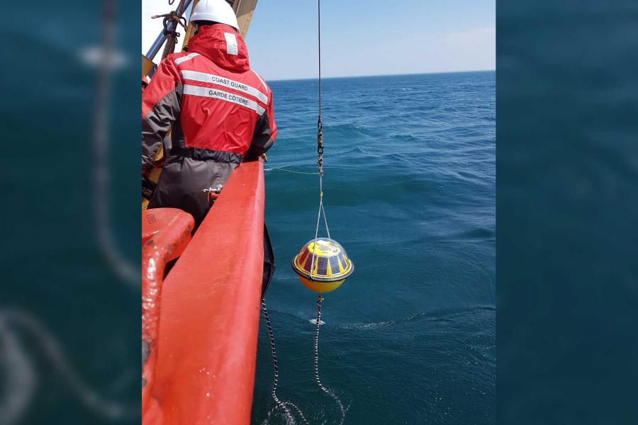 A wave buoy being lowered into the water.