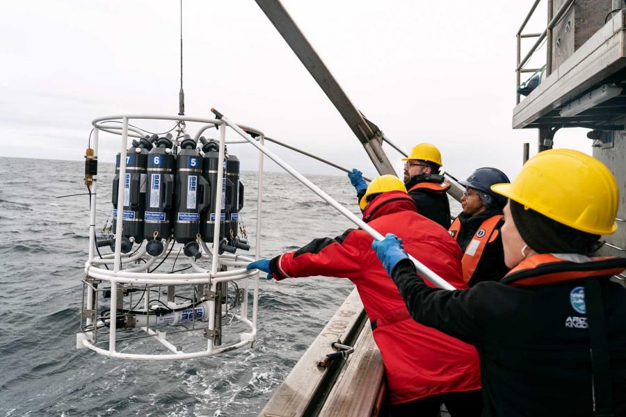 researchers lowering equipment into the water from the William Kennedy.