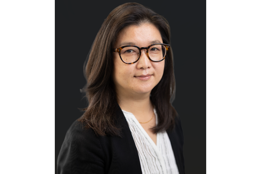 woman with longer layered dark hair and glasses