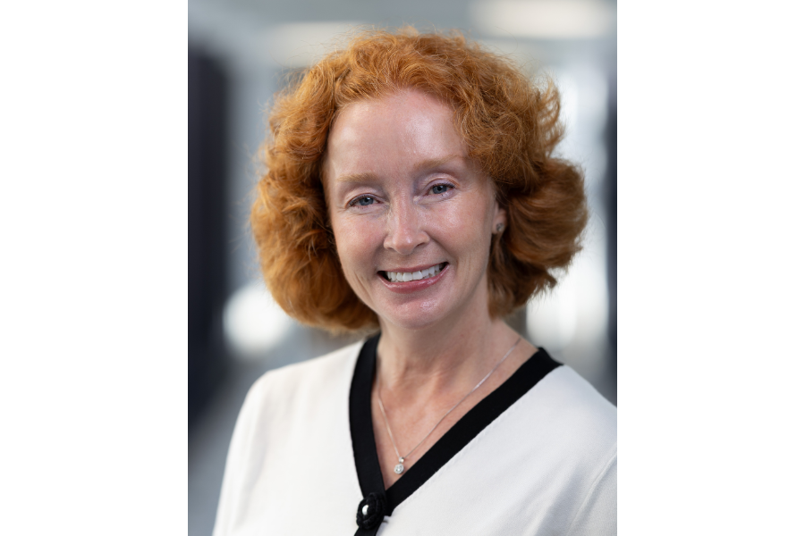 head shot woman with red chin length curly hair