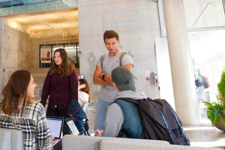 A small group of students standing together in a lounge area.