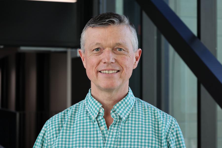 James Dietrich stands posing and smiling for the camera