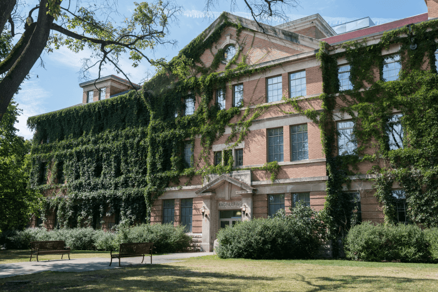 The University of Manitoba faculty of Engineering building during the summer months with vines growing over the front of the building.
