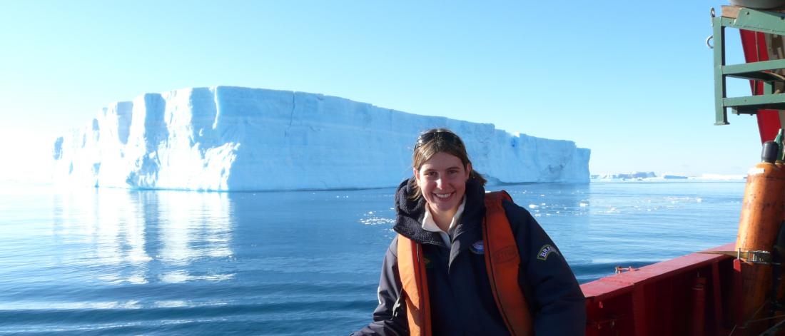 Dr. Juliana Marson on a boat posing in front of an iceberg.