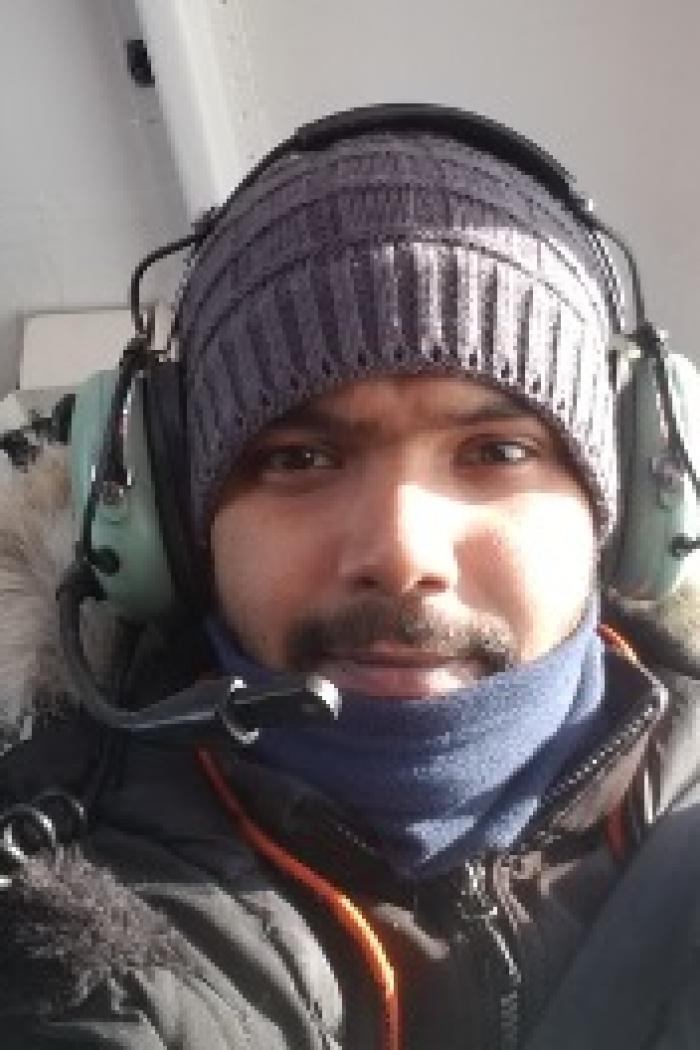 Kaushik gupta wearing warm outerwear and helicopter headphones.