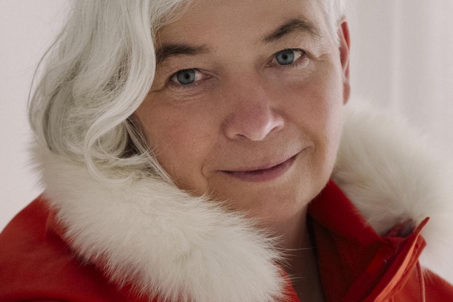 Dorthe Dahl Jensen in red coat with white fur collar smiling at camera.