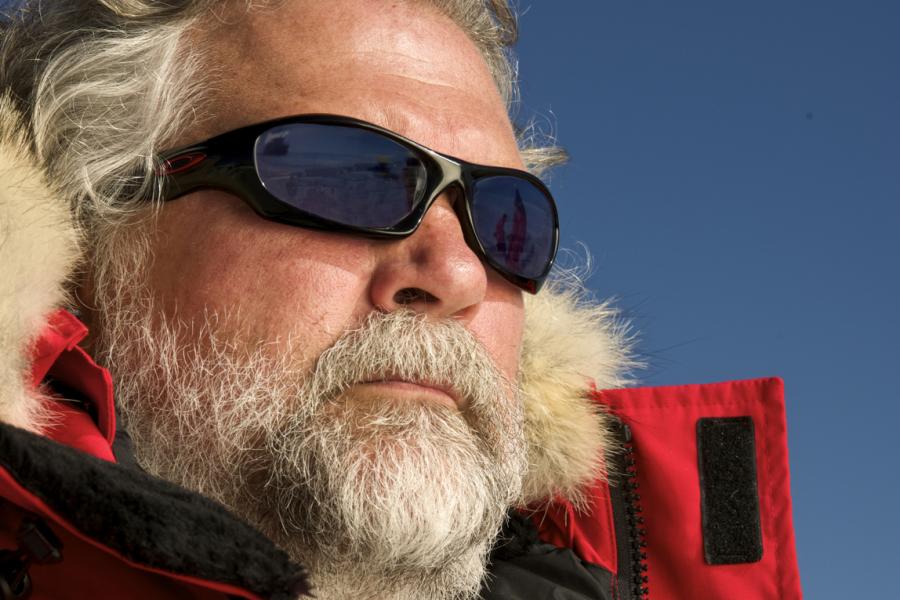 Doctor david barber in red parka and sunglasses standing outdoors.