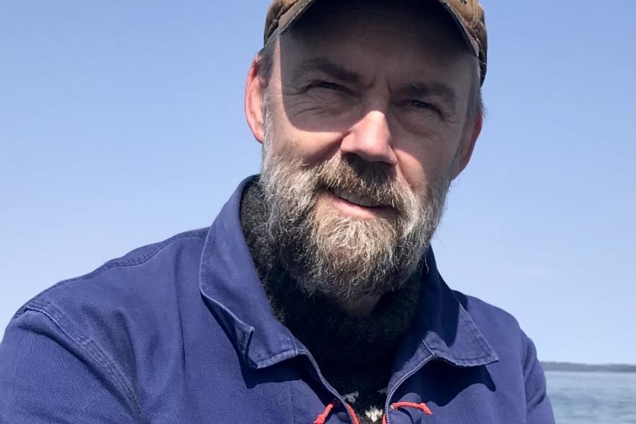 Doctor søren rysgaard outdoors wearing blue pullover and baseball cap.