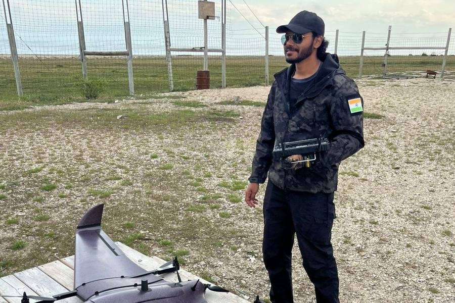 Dr. Gupta standing outside with a drone