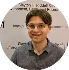 a picture of adam snyder standing in front of the faculty banner