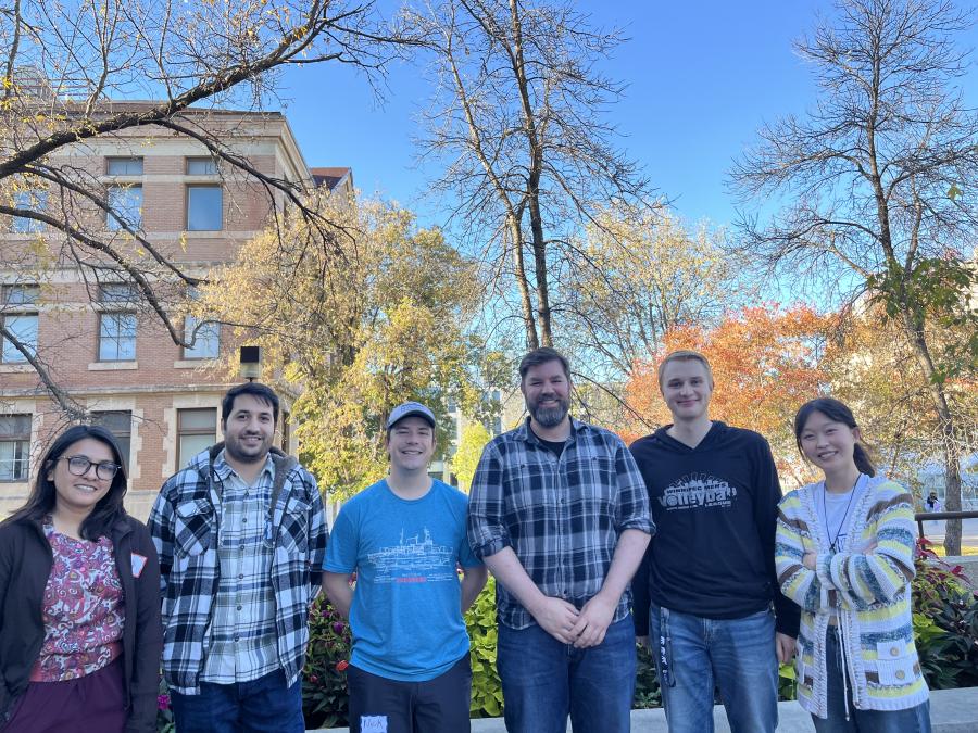 Nabanita, Mehran, Nick, Joel, Ayub, and Yiseul stand together outside on a fall day.