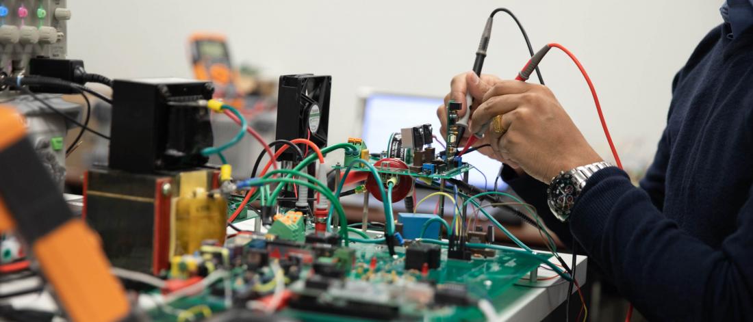 A persons hands carefully work with electrical engineering equipment.