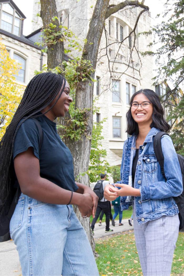 Two faculty of graduate studies students stand outdoors at the University of Manitoba Fort Garry campus.