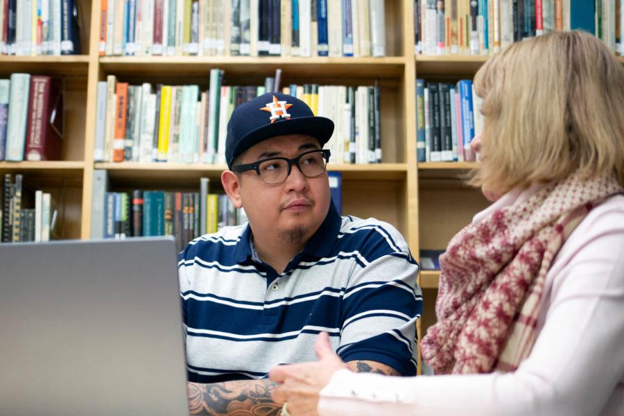 A social work student works on research in a library.